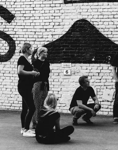 a group of people standing in front of a brick wall