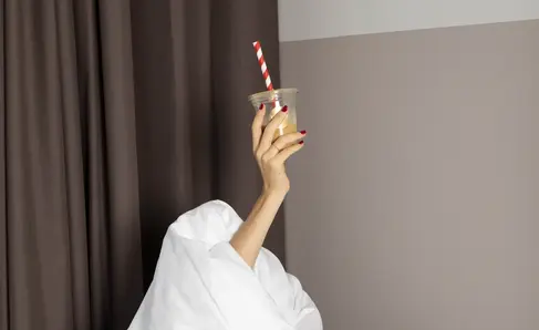 a person holding a cup with a straw