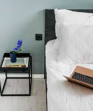 Contact Us Bed And Laptop Alt Text