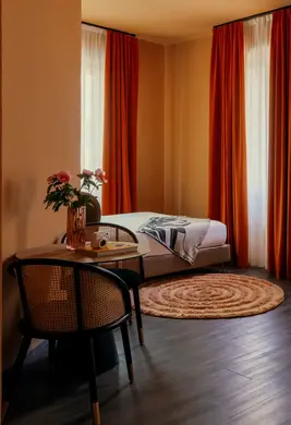 a room with a bed and chairs and a round rug