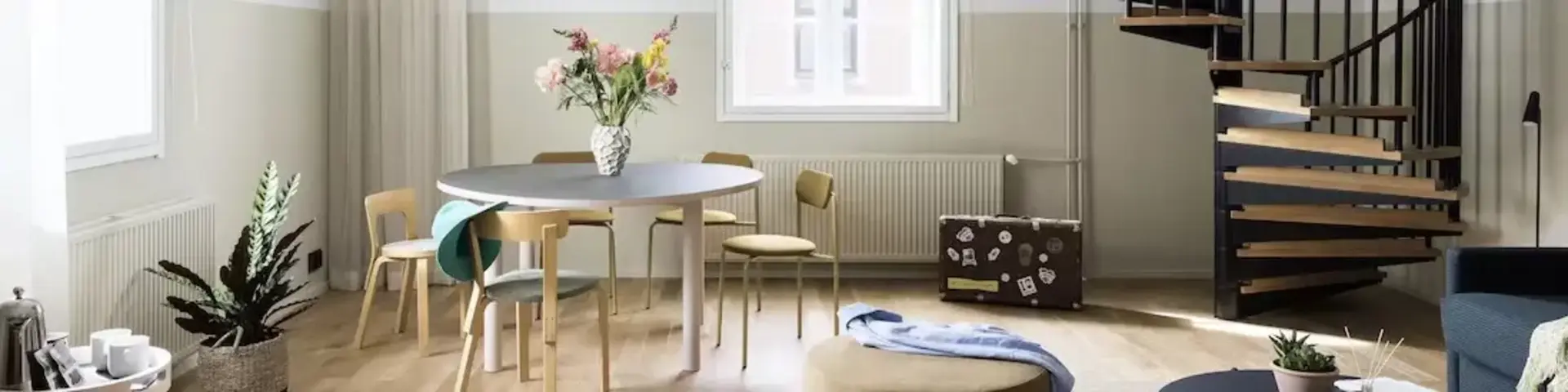 a room with a spiral staircase and a round table