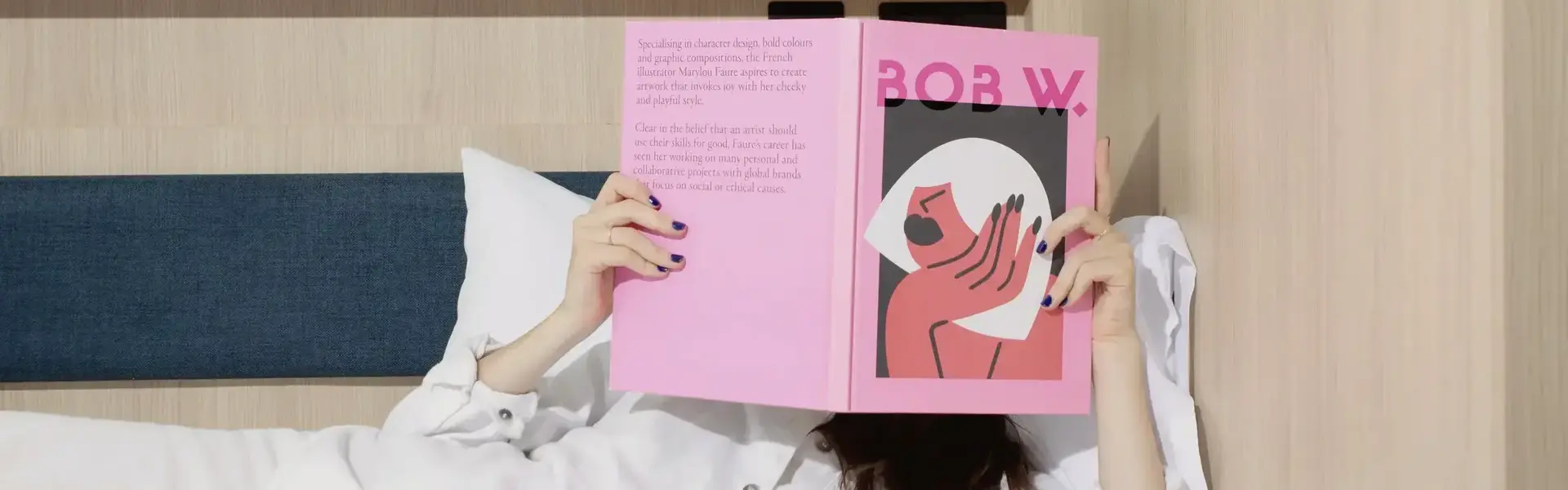 a person lying in bed reading a book