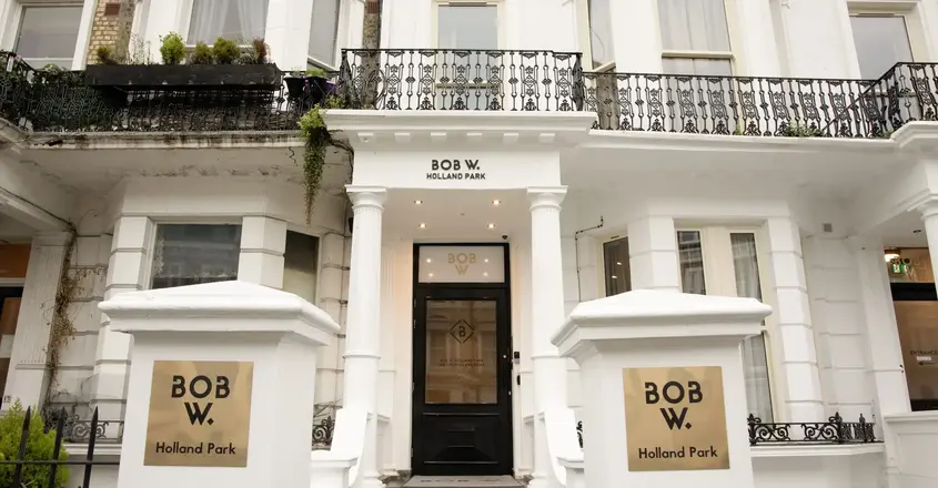 a building with a black door and white pillars